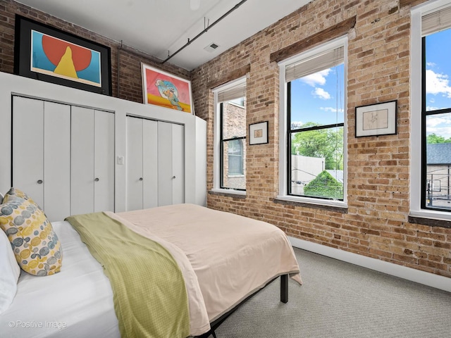 2035 W Charleston St Unit 205, Chicago, IL 60647 - carpeted bedroom with brick wall and multiple closets