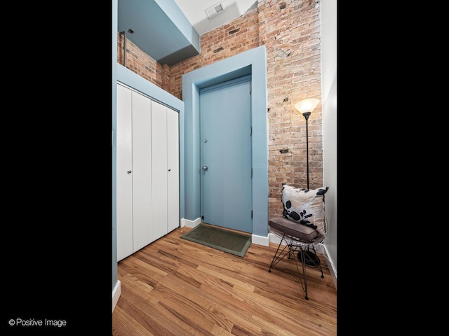 2035 W Charleston St Unit 205, Chicago, IL 60647 - entrance foyer featuring light wood-type flooring and brick wall