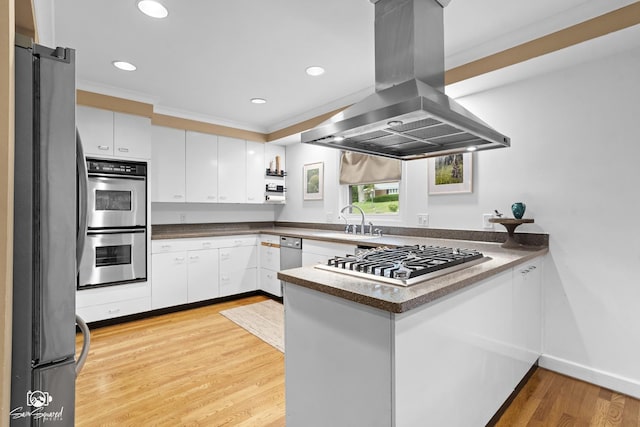 1886 N Springview Dr, Kankakee, IL 60901 - kitchen with island exhaust hood, appliances with stainless steel finishes, a peninsula, white cabinets, and light wood-style flooring