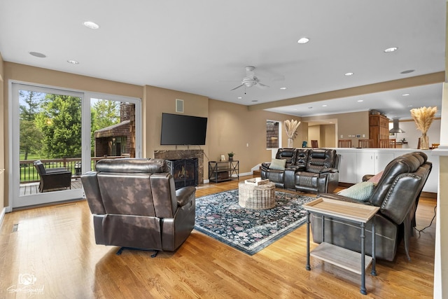 1886 N Springview Dr, Kankakee, IL 60901 - living area with ceiling fan, light wood finished floors, a warm lit fireplace, and recessed lighting