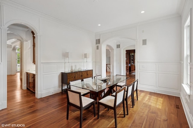 78 Wagner Rd, Northfield, IL 60093 - dining room with a decorative wall, arched walkways, ornate columns, light wood-style flooring, and ornamental molding