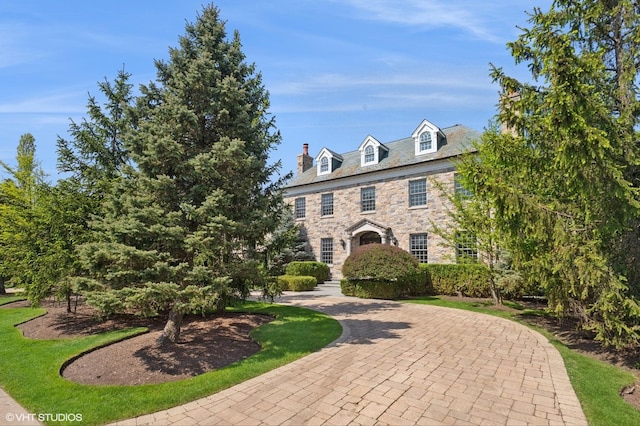 78 Wagner Rd, Northfield, IL 60093 - colonial home with a high end roof, a chimney, and stone siding