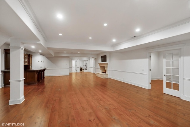 78 Wagner Rd, Northfield, IL 60093 - unfurnished living room with crown molding, hardwood / wood-style flooring, decorative columns, recessed lighting, and a fireplace with raised hearth