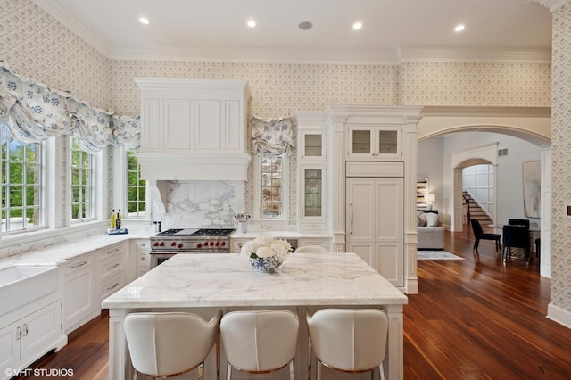 78 Wagner Rd, Northfield, IL 60093 - kitchen featuring high end stove, arched walkways, ornamental molding, wallpapered walls, and dark wood-style flooring