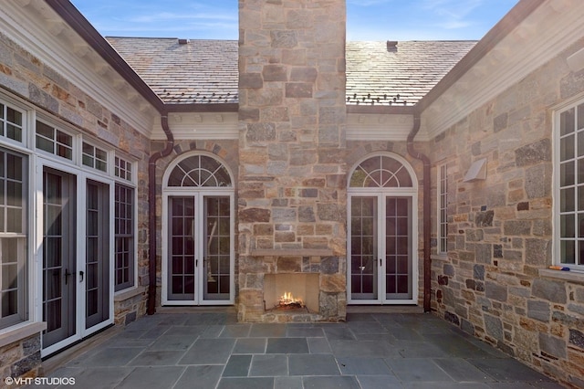 78 Wagner Rd, Northfield, IL 60093 - doorway to property with french doors, a chimney, stone siding, a high end roof, and a patio