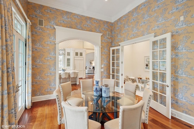 78 Wagner Rd, Northfield, IL 60093 - dining area featuring wood finished floors, wallpapered walls, french doors, arched walkways, and crown molding