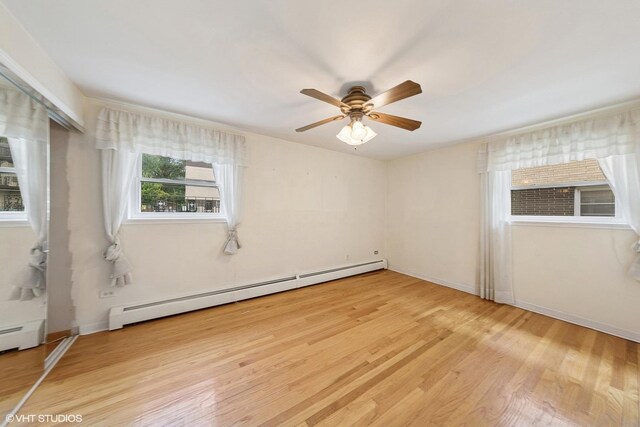 935 8th Ave Unit 1, La Grange, IL 60525 - unfurnished bedroom featuring baseboard heating, light wood finished floors, and a ceiling fan