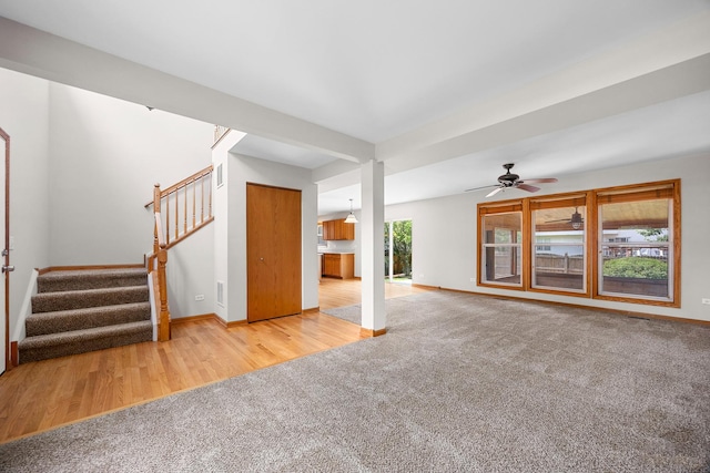 1301 Bridgehampton Dr, Plainfield, IL 60586 - unfurnished living room featuring stairway, carpet flooring, ceiling fan, and wood finished floors