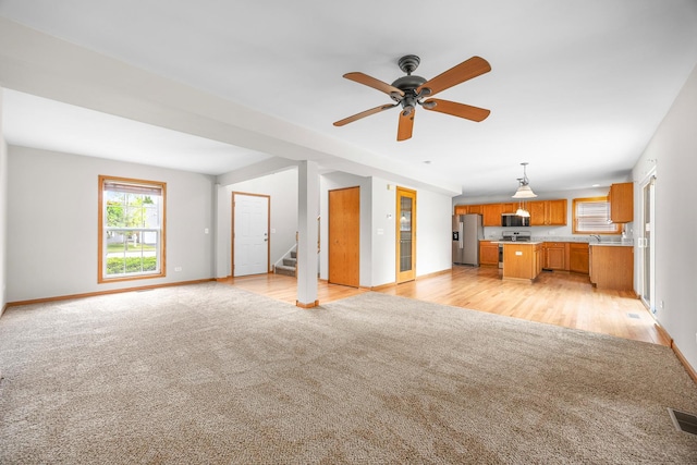 1301 Bridgehampton Dr, Plainfield, IL 60586 - unfurnished living room featuring light colored carpet, stairway, and a ceiling fan