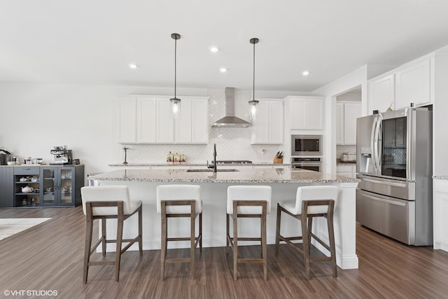 12906 S Sydney Cir, Plainfield, IL 60585 - kitchen featuring appliances with stainless steel finishes, wall chimney range hood, backsplash, dark wood-style flooring, and white cabinetry
