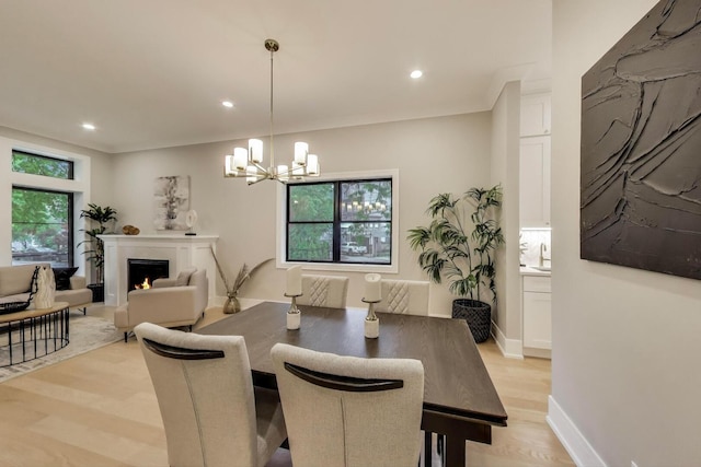 2902 N Seeley Ave, Chicago, IL 60618 - dining area with light wood finished floors, a chandelier, healthy amount of natural light, recessed lighting, and a warm lit fireplace