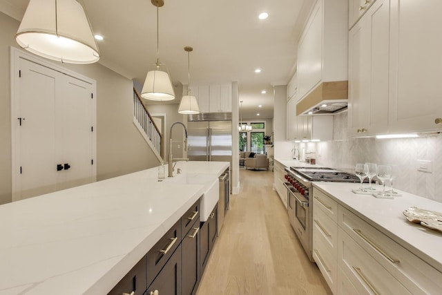 2902 N Seeley Ave, Chicago, IL 60618 - kitchen featuring high end range, white cabinets, recessed lighting, light wood finished floors, and hanging light fixtures
