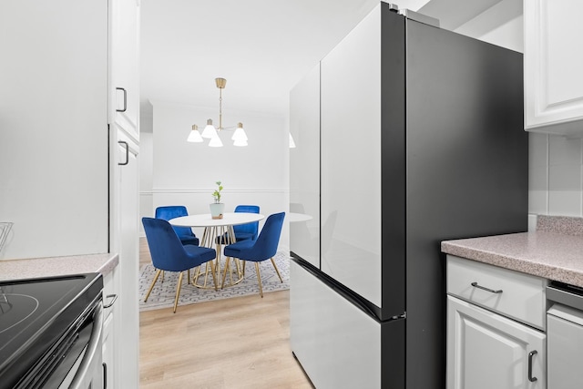 429 Wesley Ave Unit 301, Oak Park, IL 60302 - kitchen with appliances with stainless steel finishes, light wood-style floors, a chandelier, white cabinets, and light countertops