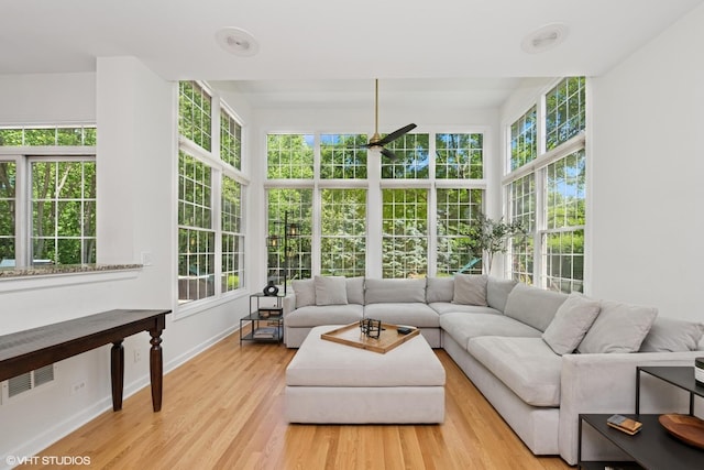 sunroom featuring baseboards and wood finished floors