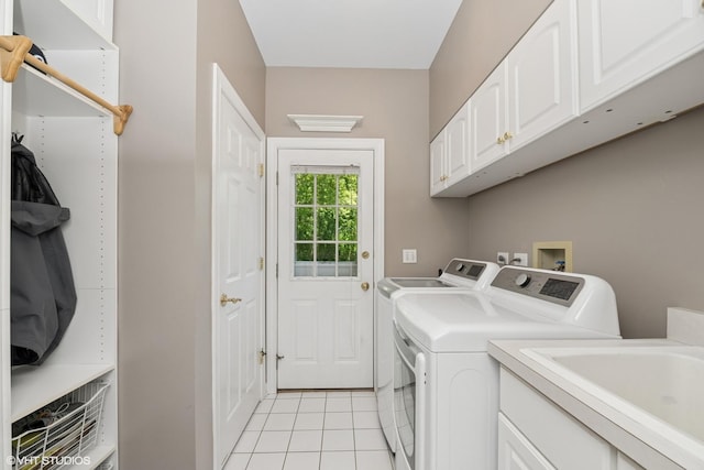laundry area featuring washer and clothes dryer, cabinet space, and light tile patterned floors