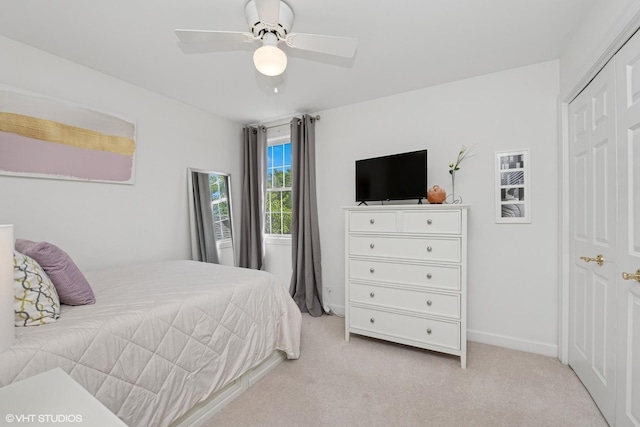 bedroom with light carpet, a ceiling fan, and a closet