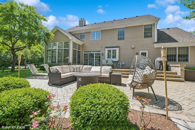 rear view of property featuring an outdoor living space with a fire pit, a sunroom, a patio area, and a chimney