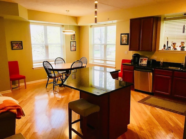 77 N Quentin Rd Unit 202, Palatine, IL 60067 - kitchen with stainless steel dishwasher, dark countertops, dark brown cabinets, light wood-type flooring, and a breakfast bar area