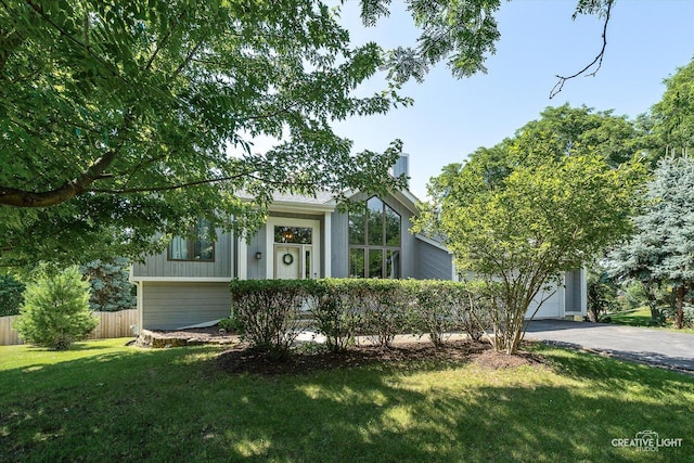 1809 Winmont Ct, Montgomery, IL 60538 - view of front of home featuring asphalt driveway, a garage, and a chimney