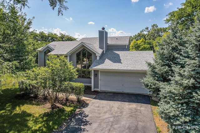 1809 Winmont Ct, Montgomery, IL 60538 - view of front of house featuring a chimney, a garage, driveway, and a shingled roof