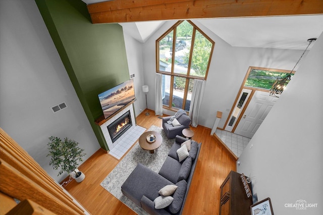 1809 Winmont Ct, Montgomery, IL 60538 - living room featuring a tiled fireplace, wood finished floors, and a chandelier