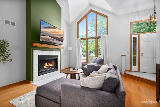 1809 Winmont Ct, Montgomery, IL 60538 - living area with a tiled fireplace, healthy amount of natural light, wood finished floors, and high vaulted ceiling