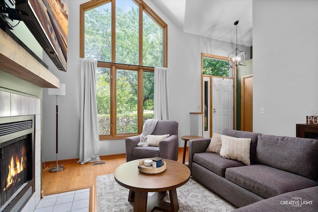 1809 Winmont Ct, Montgomery, IL 60538 - living room featuring a fireplace, a chandelier, a towering ceiling, and light tile patterned flooring