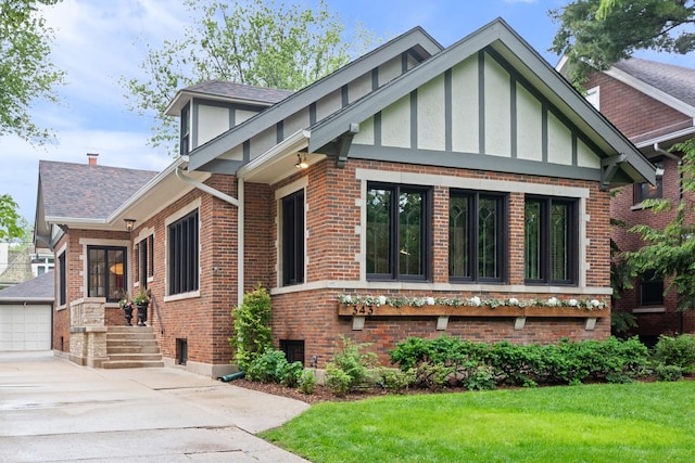 343 Washington Ave, Wilmette, IL 60091 - tudor home with brick siding, a front yard, stucco siding, and roof with shingles