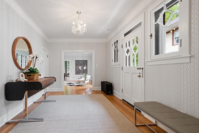 343 Washington Ave, Wilmette, IL 60091 - foyer entrance featuring light wood-style flooring, a chandelier, wallpapered walls, and crown molding