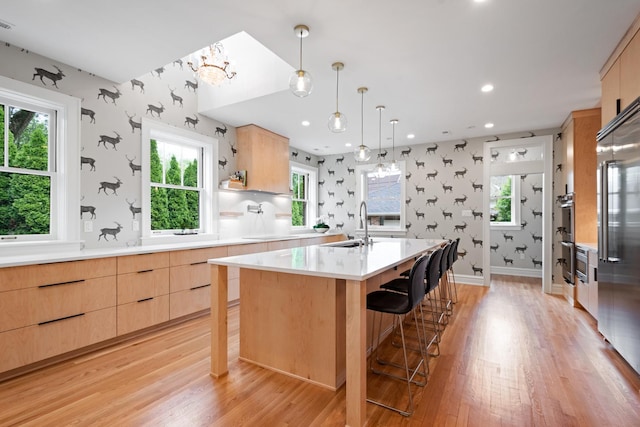 343 Washington Ave, Wilmette, IL 60091 - kitchen featuring light brown cabinets, modern cabinets, wallpapered walls, light countertops, and light wood-style flooring
