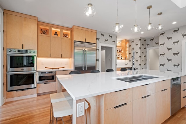 343 Washington Ave, Wilmette, IL 60091 - kitchen featuring stainless steel appliances, light brown cabinets, wallpapered walls, light wood-style floors, and pendant lighting