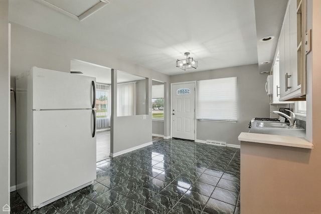 5301 State Rd, Burbank, IL 60459 - kitchen with freestanding refrigerator, light countertops, white cabinets, and dark marble finish flooring