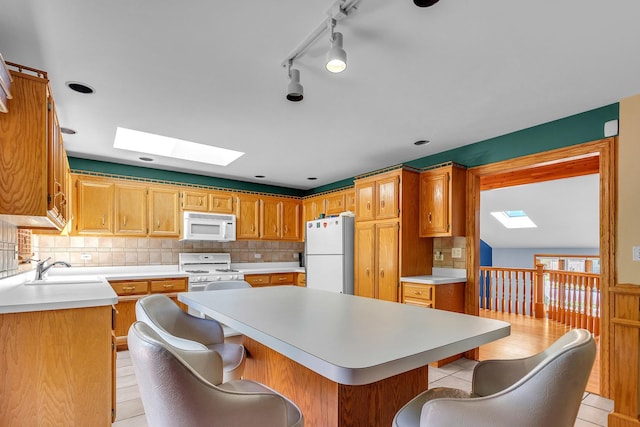 11254 S Whipple St, Chicago, IL 60655 - kitchen featuring white appliances, a skylight, light countertops, and a center island
