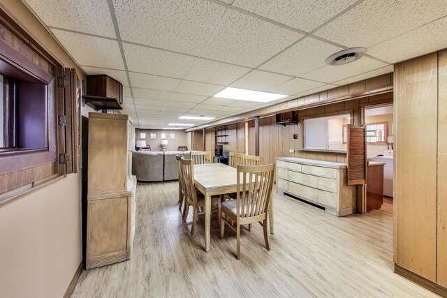 5836 S Menard Ave, Chicago, IL 60638 - dining area featuring a paneled ceiling, light wood-style floors, wooden walls, and washer / clothes dryer