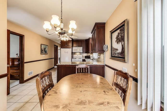 5836 S Menard Ave, Chicago, IL 60638 - dining space featuring a chandelier and light tile patterned floors