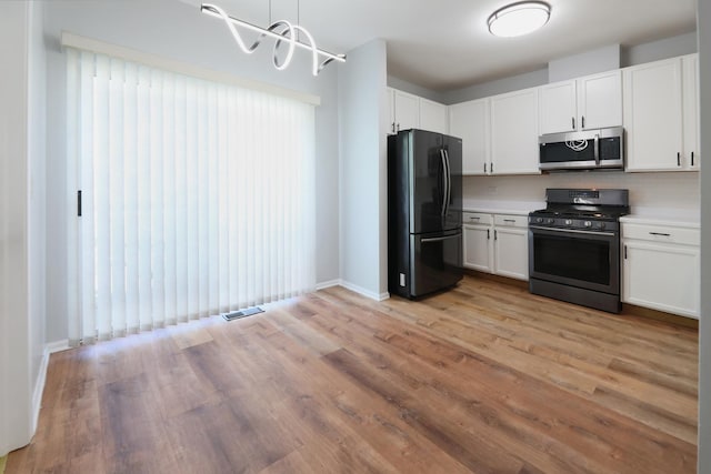 1653 Geneva Dr, Wheeling, IL 60090 - kitchen featuring black appliances, white cabinetry, and light countertops