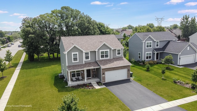 26065 S White Oak Trl, Channahon, IL 60410 - traditional-style home with a porch, asphalt driveway, a front lawn, and an attached garage