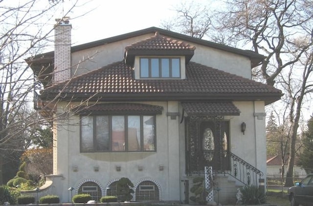 462 Repton Rd, Riverside, IL 60546 - view of front facade with stucco siding, a tile roof, and a chimney