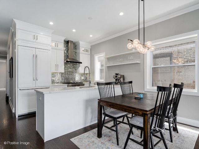 1841 N Sheffield Ave Unit 2, Chicago, IL 60614 - kitchen with paneled fridge, wall chimney range hood, backsplash, white cabinetry, and crown molding