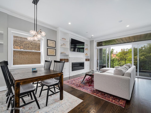 1841 N Sheffield Ave Unit 2, Chicago, IL 60614 - dining space featuring a glass covered fireplace, dark wood-style flooring, crown molding, built in shelves, and recessed lighting