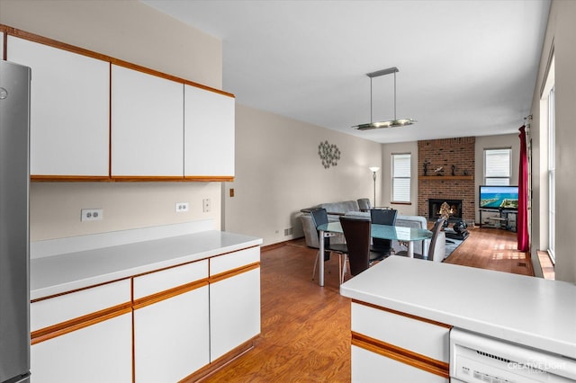 1348 Amaranth Dr, Naperville, IL 60564 - kitchen featuring open floor plan, light wood finished floors, white dishwasher, a fireplace, and light countertops