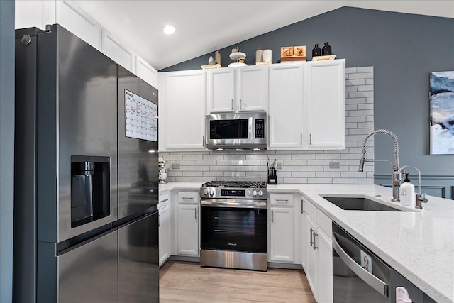 2447 Saddle Ridge Dr, Joliet, IL 60432 - kitchen with appliances with stainless steel finishes, lofted ceiling, decorative backsplash, light wood finished floors, and light stone countertops