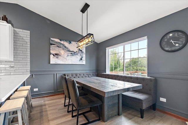 2447 Saddle Ridge Dr, Joliet, IL 60432 - dining space with lofted ceiling, wood finished floors, breakfast area, a wainscoted wall, and a decorative wall