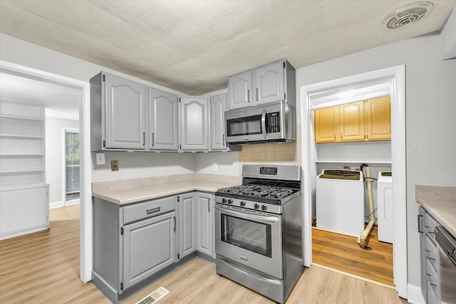 724 Dover Pl, Champaign, IL 61820 - kitchen with stainless steel appliances, gray cabinets, separate washer and dryer, and light countertops