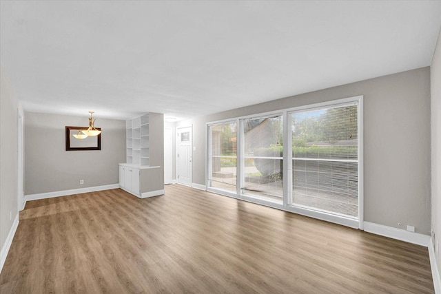 724 Dover Pl, Champaign, IL 61820 - unfurnished living room with light wood-style floors and a chandelier
