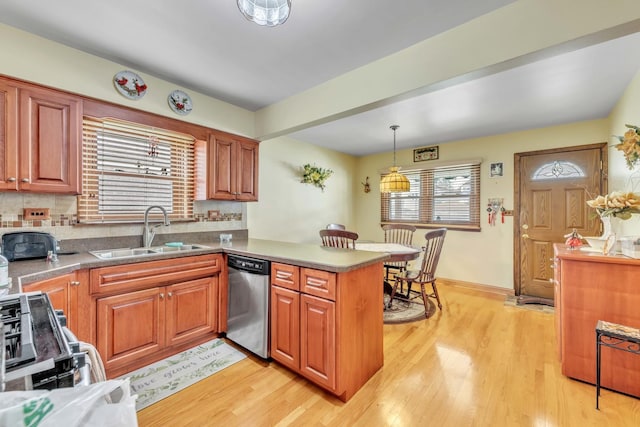 4512 S Trumbull Ave, Chicago, IL 60632 - kitchen featuring appliances with stainless steel finishes, a peninsula, light wood-style flooring, backsplash, and decorative light fixtures