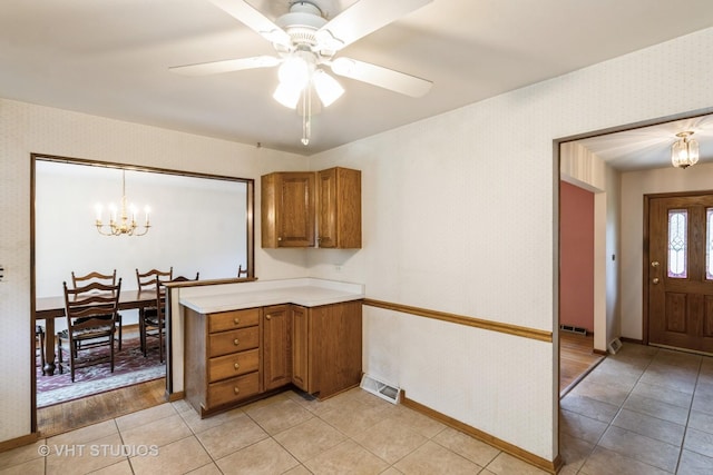 5341 Grand Ave, Downers Grove, IL 60515 - kitchen featuring brown cabinetry, a chandelier, light countertops, light tile patterned floors, and wallpapered walls