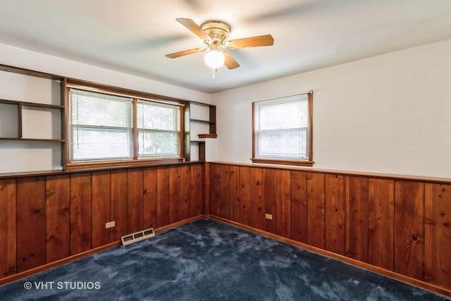 5341 Grand Ave, Downers Grove, IL 60515 - unfurnished room with a wainscoted wall, ceiling fan, wood walls, and dark colored carpet
