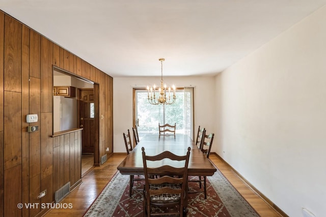 5341 Grand Ave, Downers Grove, IL 60515 - dining room featuring a chandelier, wooden walls, and wood finished floors