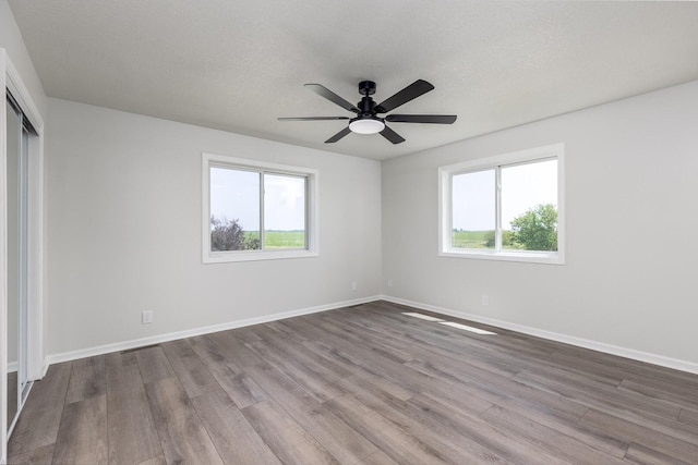 3472 N Il St Unit 23, Ottawa, IL 61350 - unfurnished bedroom featuring multiple windows, wood finished floors, a closet, and ceiling fan